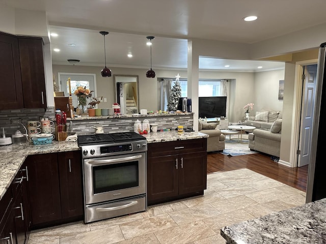 kitchen featuring tasteful backsplash, gas stove, light stone counters, and dark brown cabinetry
