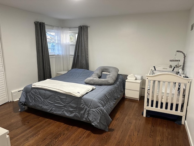 bedroom featuring dark hardwood / wood-style flooring and baseboard heating