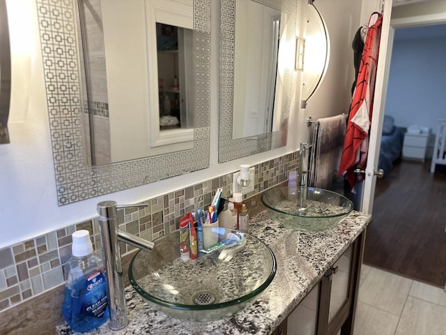 bathroom featuring tile patterned flooring, vanity, and backsplash