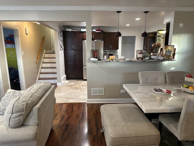 dining room with wood-type flooring and ornamental molding