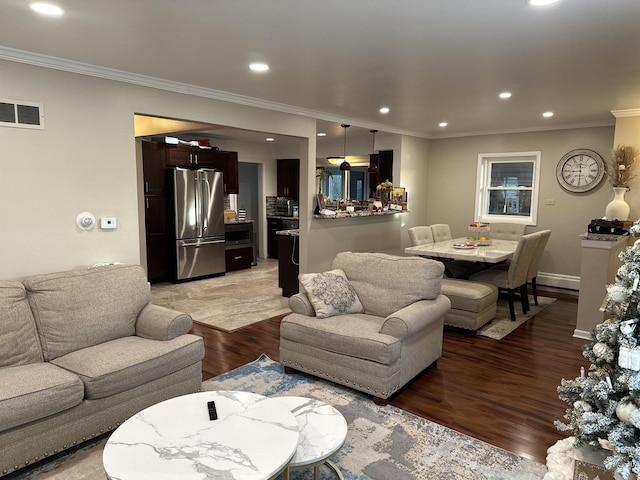 living room with ornamental molding, a baseboard heating unit, and light hardwood / wood-style flooring
