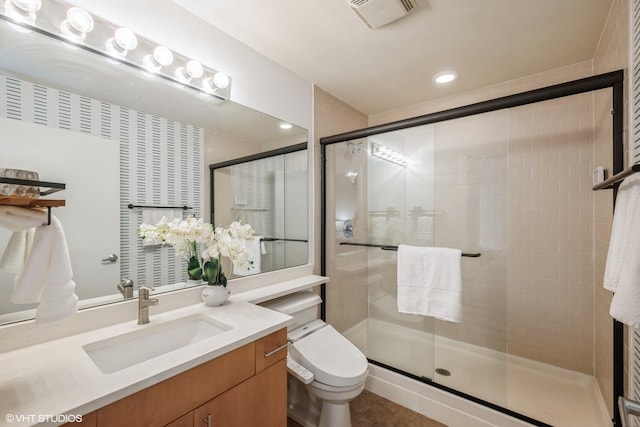 bathroom with vanity, toilet, and a shower with shower door