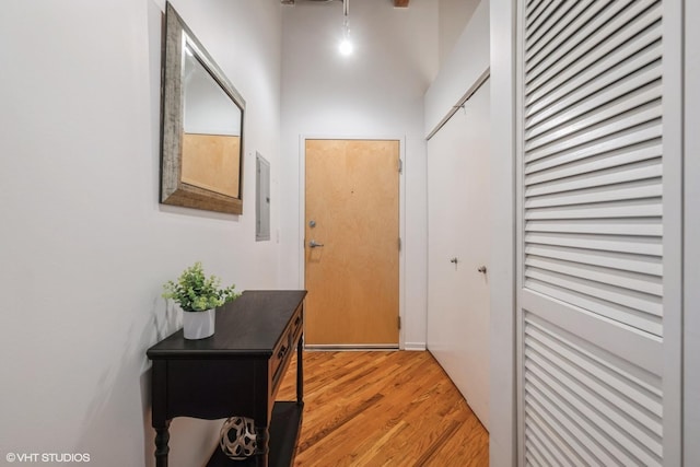 corridor with hardwood / wood-style flooring and electric panel