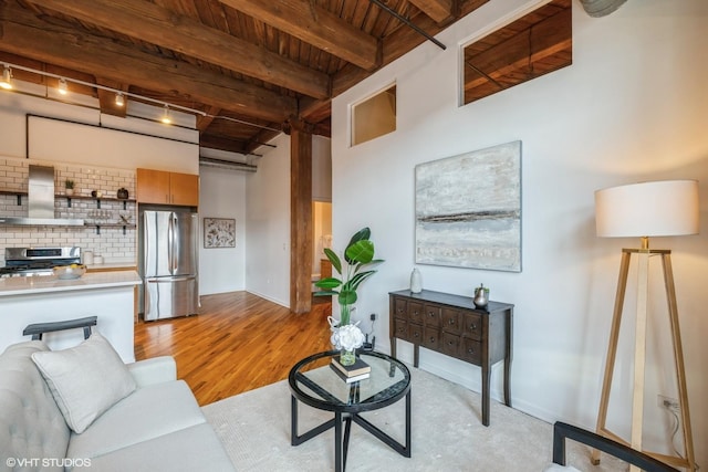 living room with light hardwood / wood-style flooring, wooden ceiling, and beamed ceiling