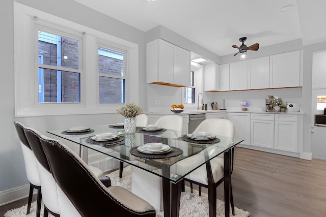 dining room featuring ceiling fan, a healthy amount of sunlight, sink, and light hardwood / wood-style floors