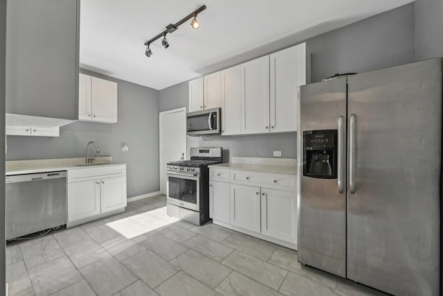 kitchen with white cabinetry, track lighting, appliances with stainless steel finishes, and sink