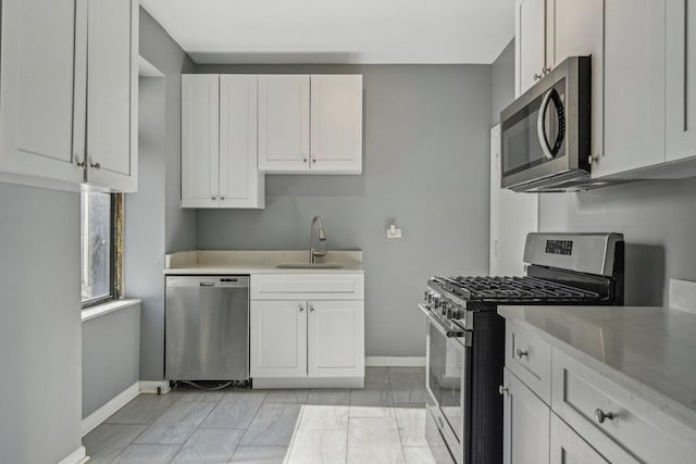 kitchen with sink, white cabinets, and appliances with stainless steel finishes