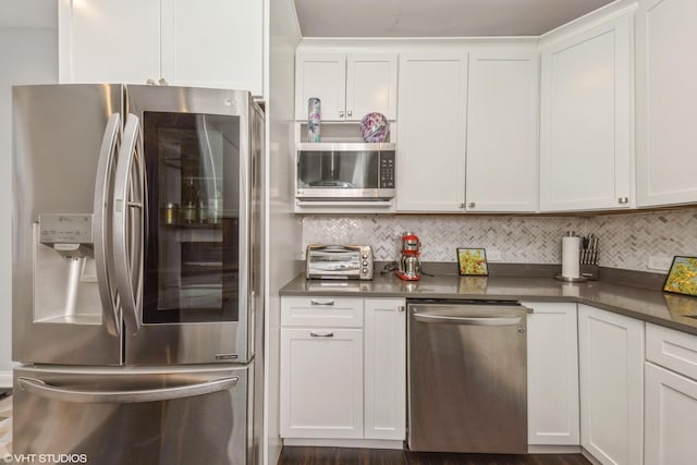 kitchen featuring decorative backsplash, white cabinets, and appliances with stainless steel finishes