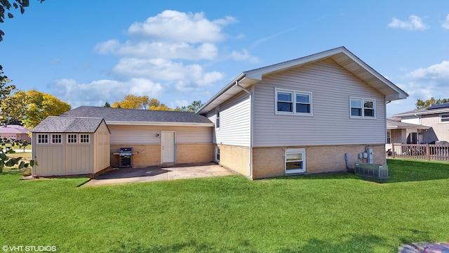 back of house with cooling unit, a lawn, a shed, and a patio area