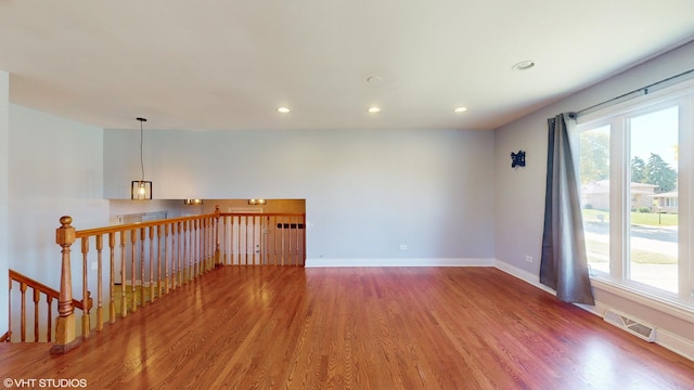 spare room featuring a healthy amount of sunlight and hardwood / wood-style floors