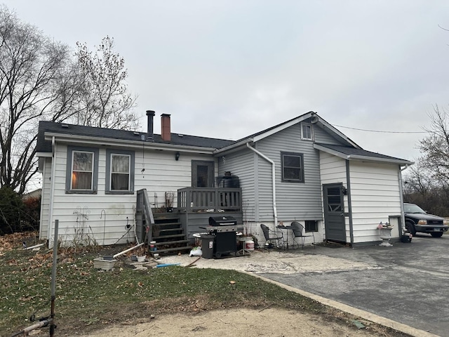 rear view of property with a deck and a patio