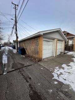 view of snowy exterior featuring a garage