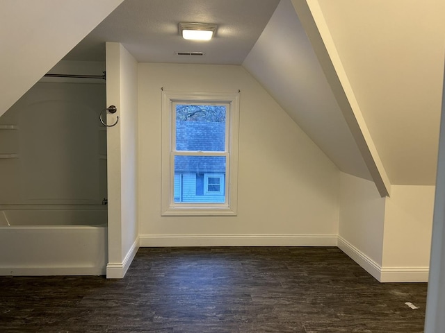 bonus room with lofted ceiling and dark hardwood / wood-style floors