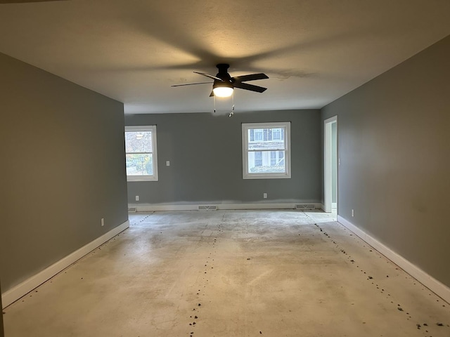 spare room with ceiling fan and plenty of natural light