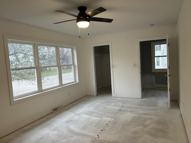 unfurnished bedroom featuring ceiling fan, a spacious closet, and a closet