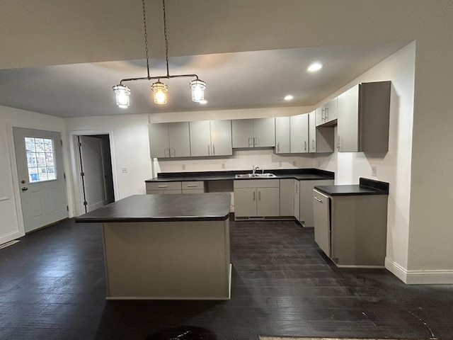 kitchen with sink, gray cabinetry, decorative light fixtures, a center island, and dark hardwood / wood-style flooring