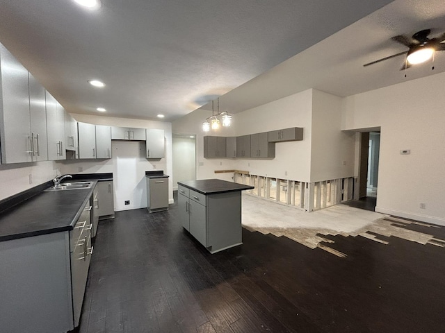 kitchen with sink, a center island, gray cabinetry, and dark wood-type flooring