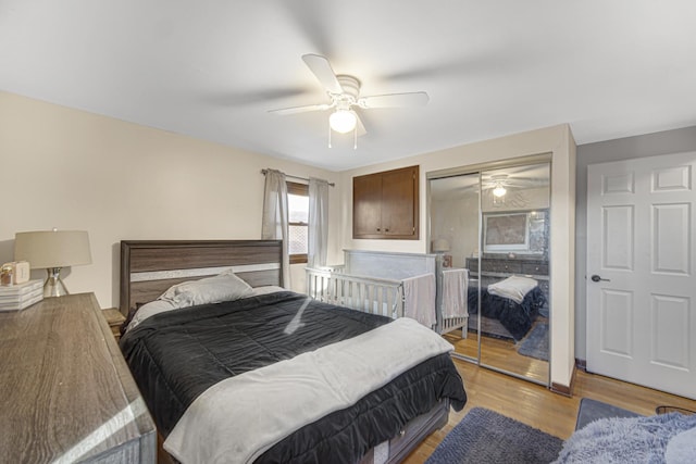 bedroom with light hardwood / wood-style flooring, ceiling fan, and a closet