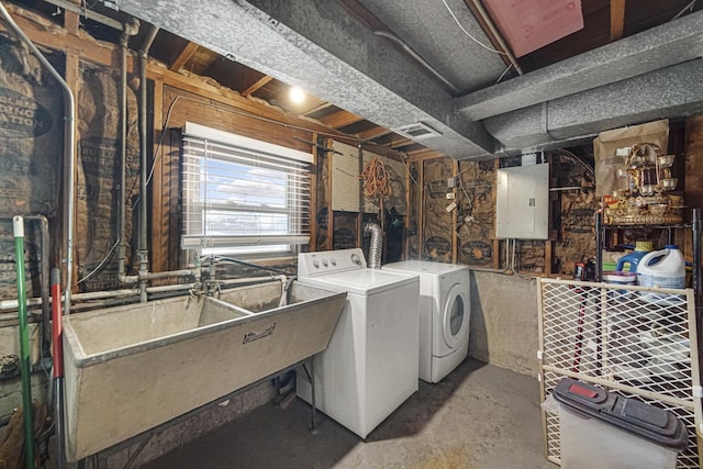 clothes washing area featuring washing machine and clothes dryer, electric panel, and sink