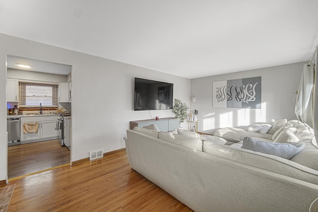 living room with hardwood / wood-style flooring and sink