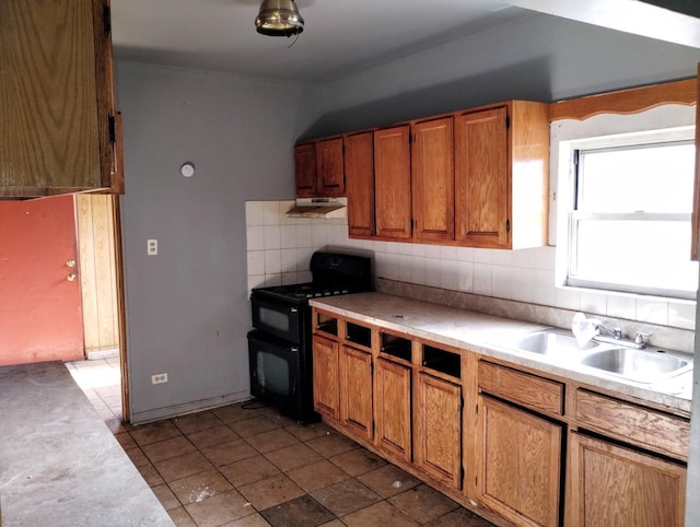 kitchen featuring double oven range, backsplash, and sink