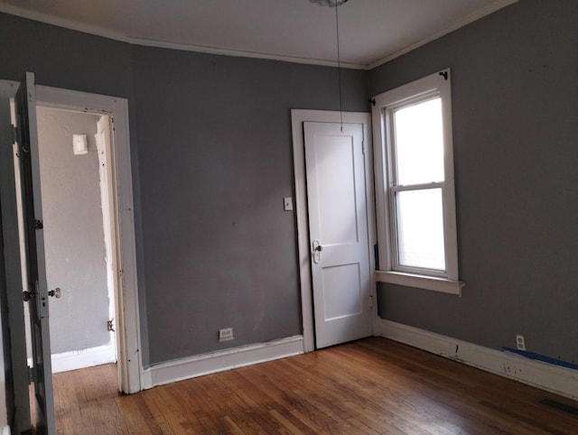 empty room with crown molding and hardwood / wood-style flooring