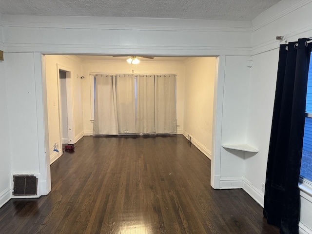 spare room featuring dark wood-type flooring and a textured ceiling