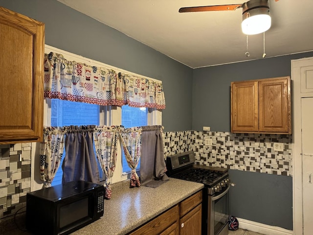 kitchen featuring tasteful backsplash, gas range, and ceiling fan