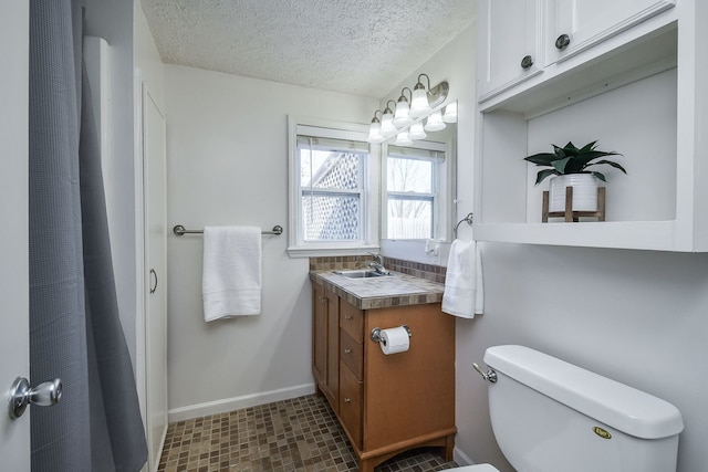 bathroom with vanity, a textured ceiling, and toilet