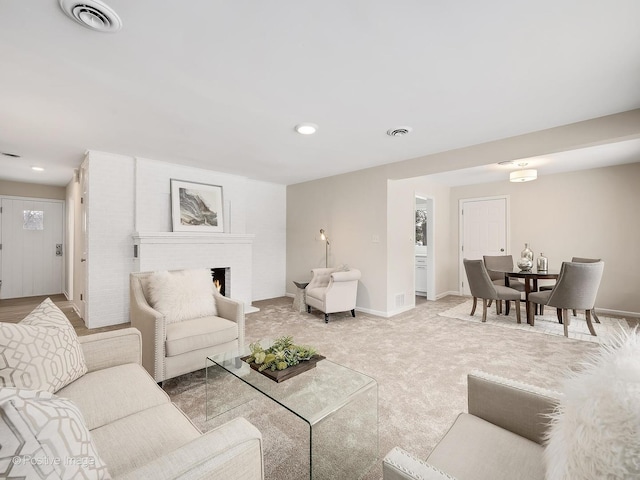 carpeted living room with a brick fireplace