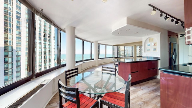 dining space with a water view and light hardwood / wood-style flooring