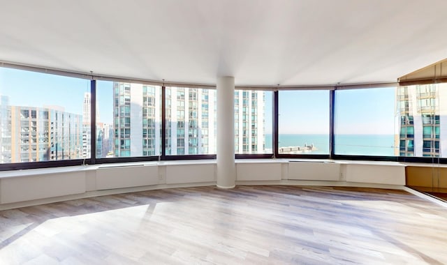 unfurnished sunroom featuring a water view and plenty of natural light