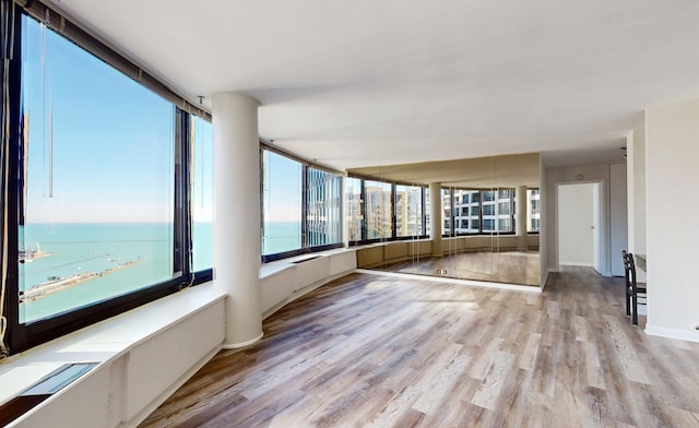 unfurnished sunroom featuring a water view