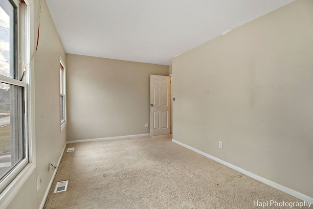 unfurnished room featuring light carpet