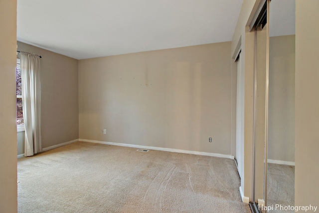 unfurnished room with light carpet