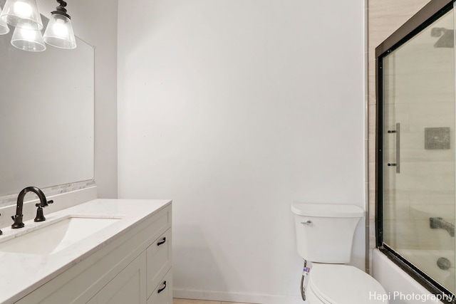 full bathroom featuring enclosed tub / shower combo, vanity, and toilet