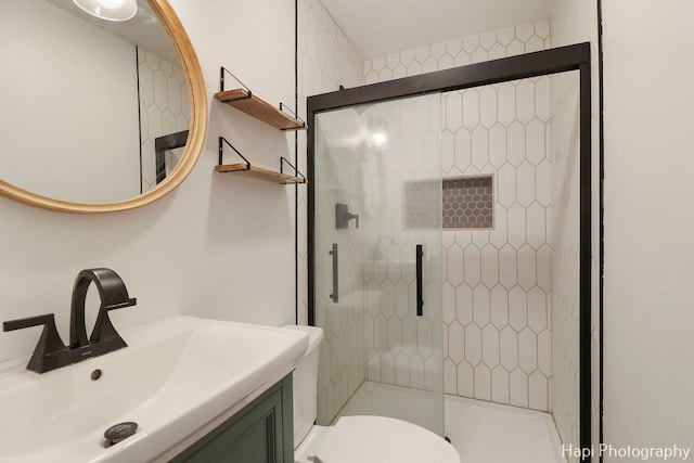 bathroom with vanity, an enclosed shower, and toilet