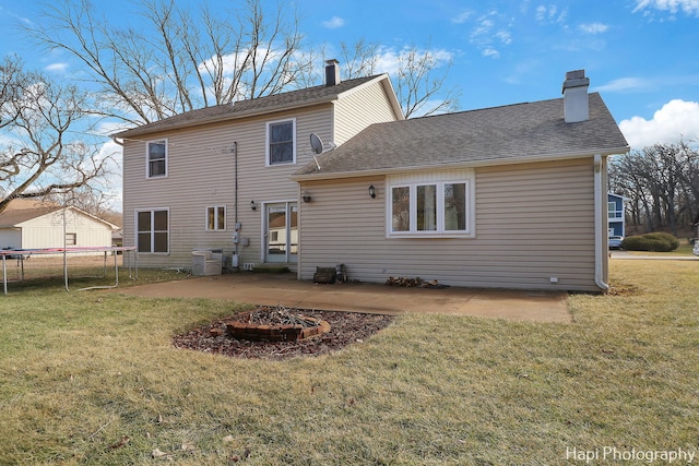 rear view of house featuring a trampoline, cooling unit, a yard, and a patio area