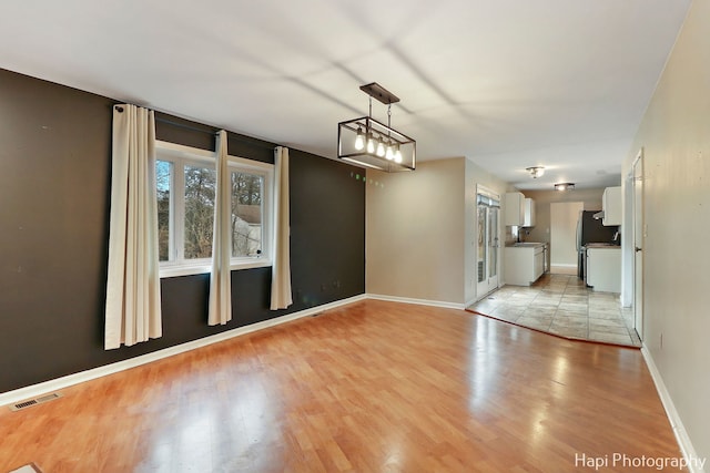 unfurnished dining area with sink and light hardwood / wood-style floors