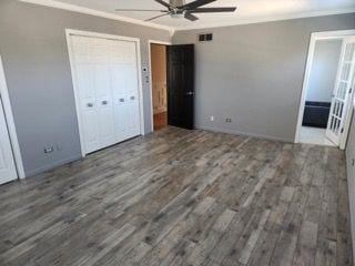 unfurnished bedroom featuring crown molding, dark wood-type flooring, and a closet