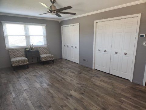 unfurnished room with crown molding, dark hardwood / wood-style floors, and ceiling fan