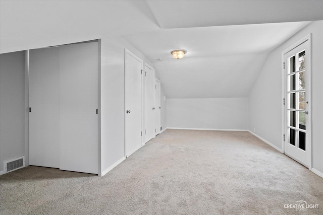 bonus room with carpet flooring and vaulted ceiling