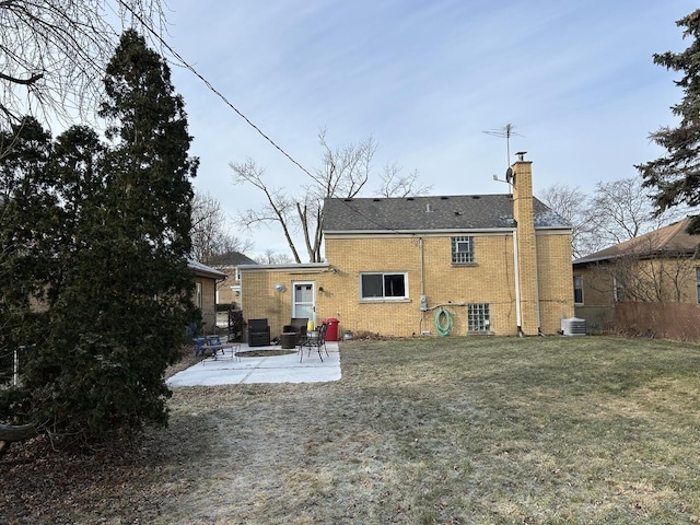 back of property with a yard, central air condition unit, and a patio area