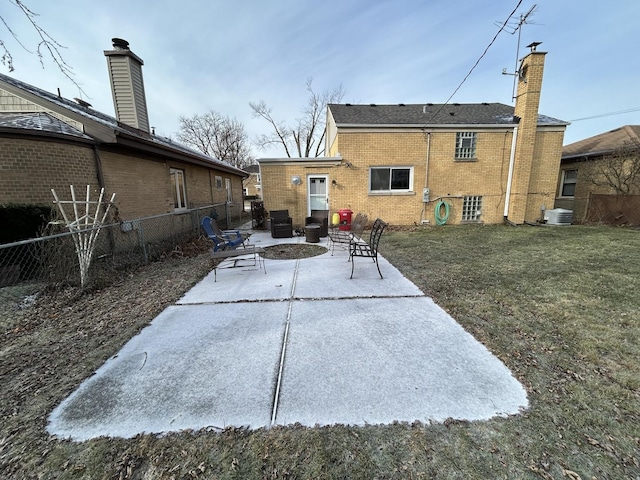 rear view of property with a yard, an outdoor fire pit, and a patio area