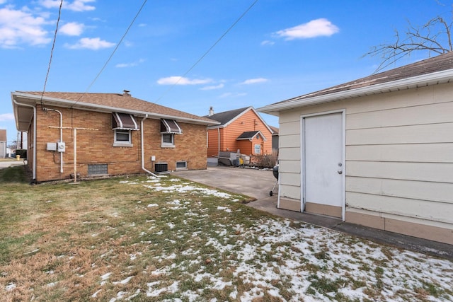 rear view of house with central AC, a lawn, and a patio