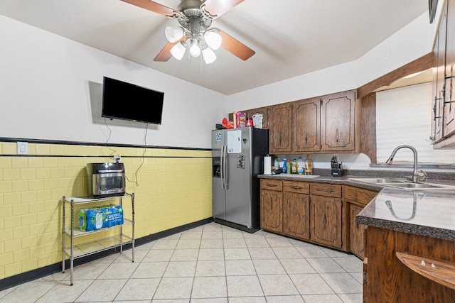 kitchen featuring tile walls, sink, stainless steel fridge, and ceiling fan