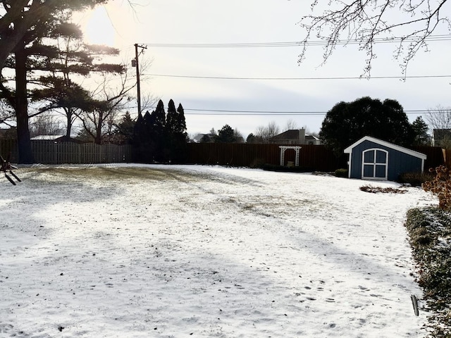 yard covered in snow with a storage unit