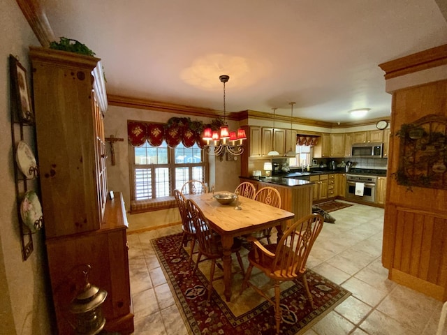 dining space featuring light tile patterned floors, crown molding, sink, and a chandelier