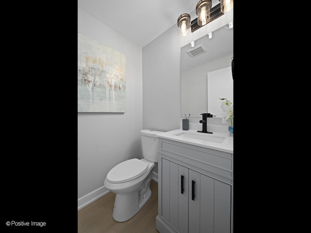 bathroom with vanity, toilet, and wood-type flooring