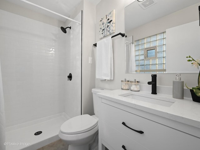 bathroom featuring a shower, vanity, and toilet